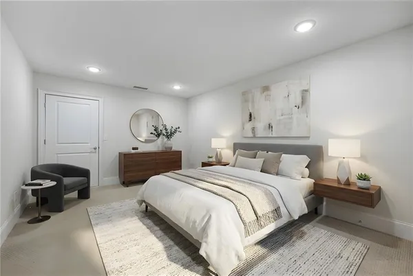 a spacious bedroom with a bed and a lamp