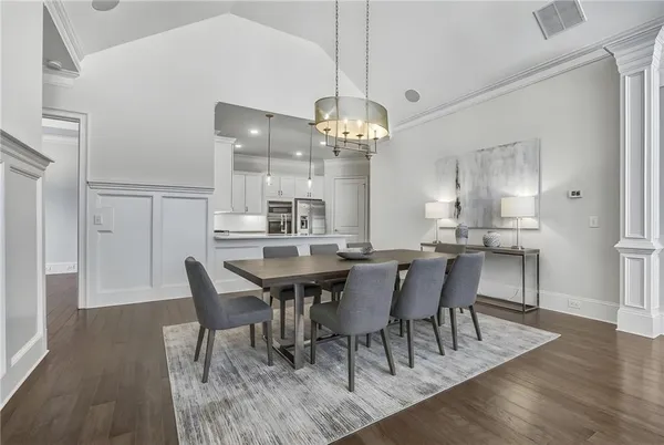 a view of a dining room and livingroom with furniture wooden floor a chandelier