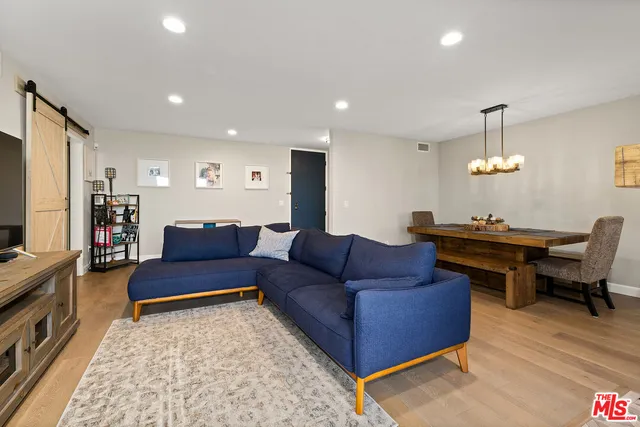 a living room with furniture a rug and a flat screen tv