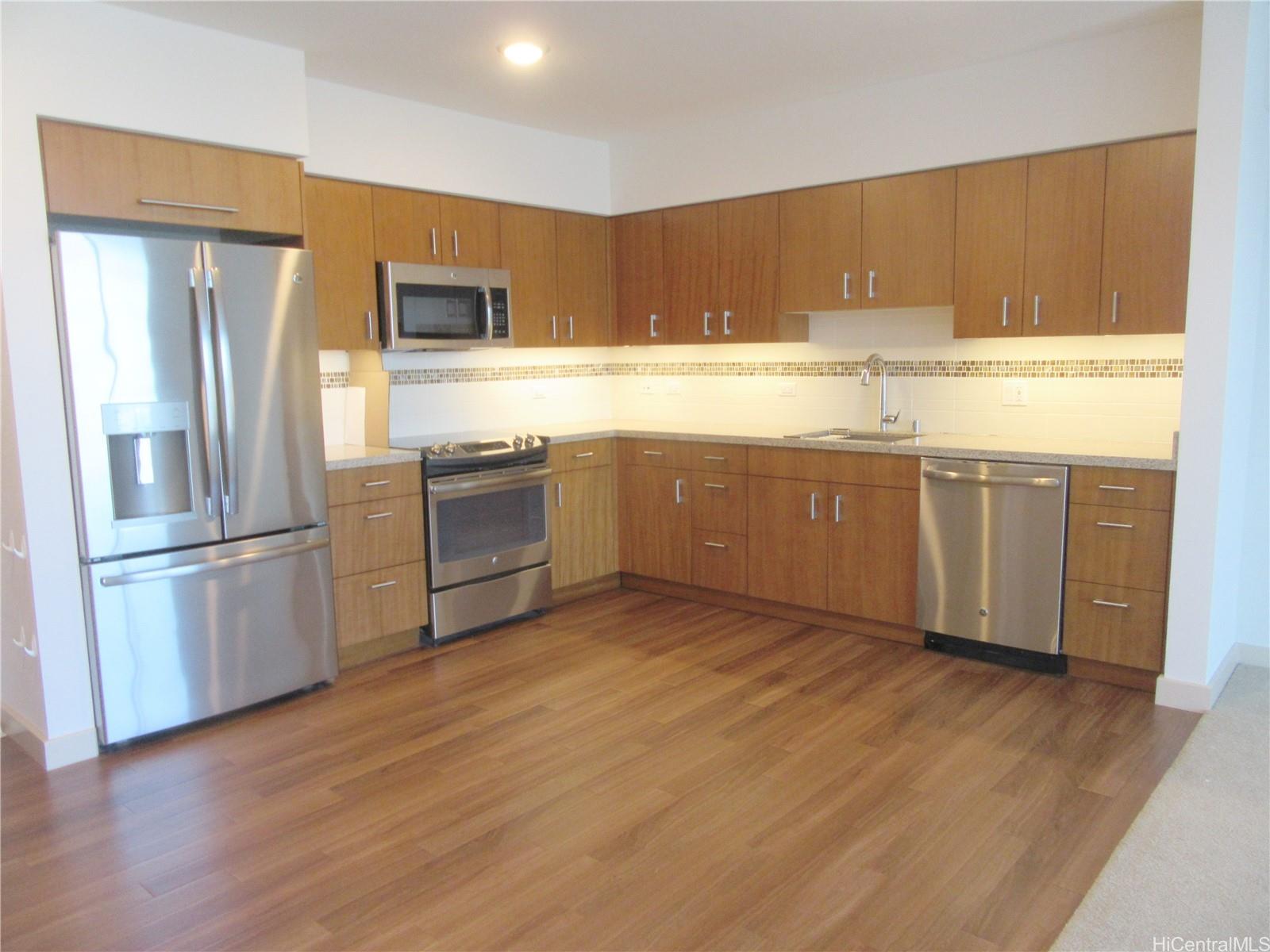 a kitchen with stainless steel appliances granite countertop a refrigerator and a stove top oven