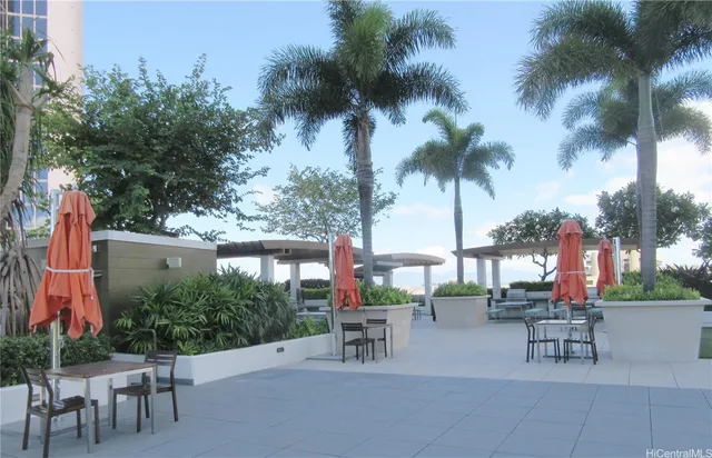 a view of a patio with a table and chairs under an umbrella