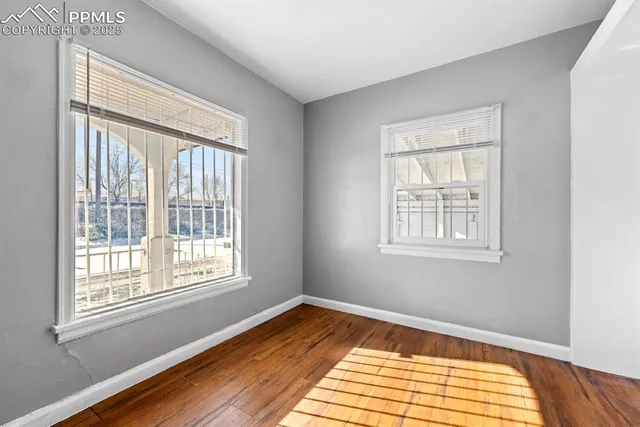 a view of a room with wooden floor and a window