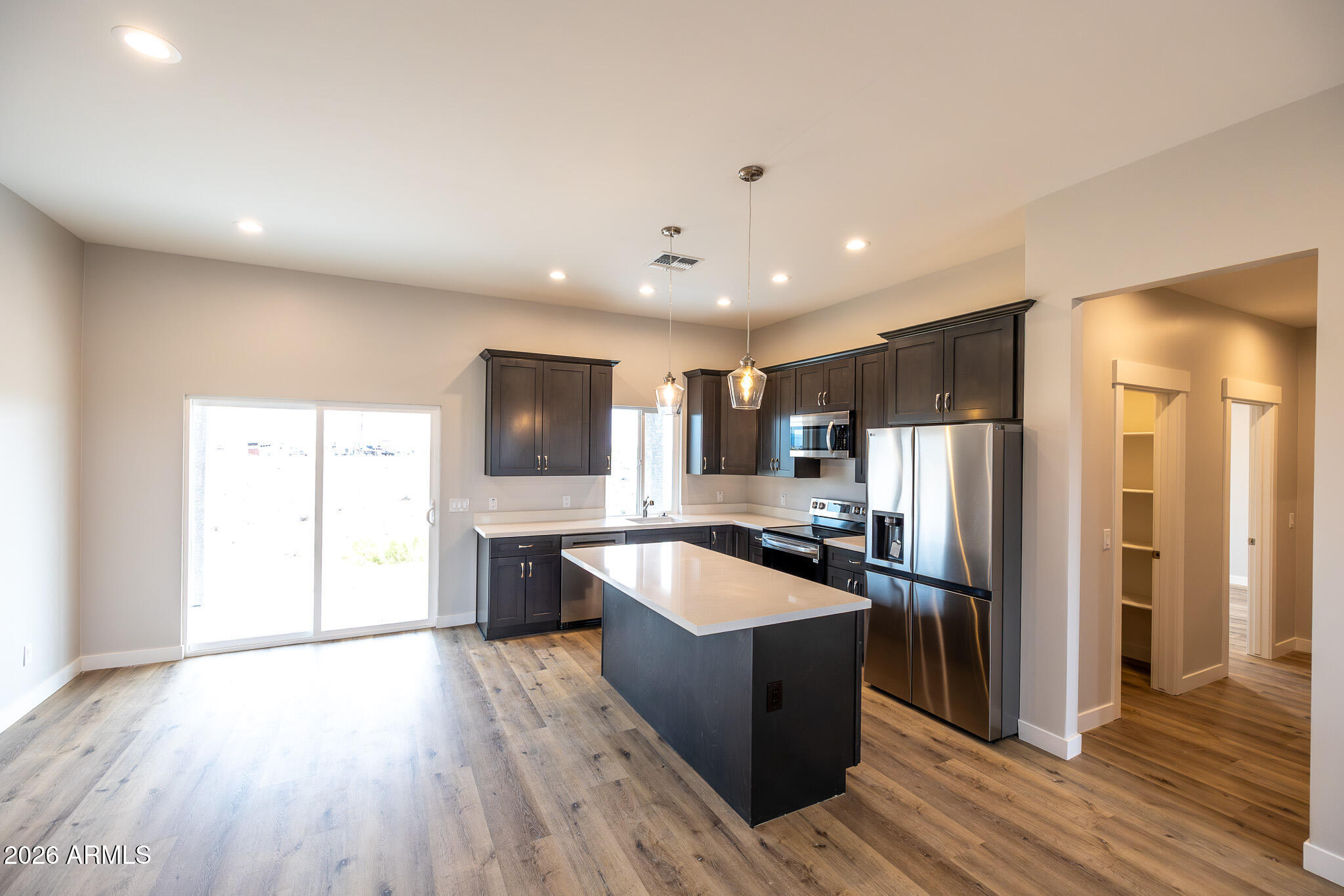 11459 East Adamsville Road Florence, AZ 85132 - Photo 7 of 63 a large kitchen with a large counter top stainless steel appliances and wooden floor