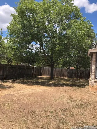 a view of a yard with wooden fence