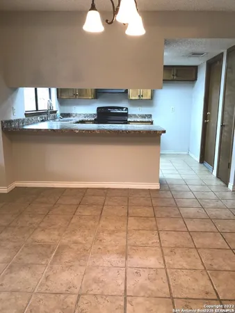 a kitchen with a stove a sink and a counter top space