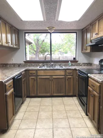 a kitchen with a stove sink and cabinets