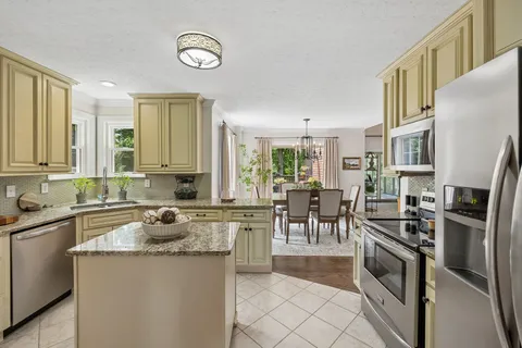 a kitchen with granite countertop a sink a stove and cabinets