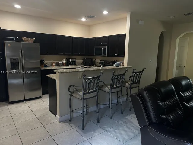 a kitchen with stainless steel appliances a sink a table and chairs