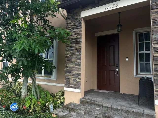 a front view of a house with plants