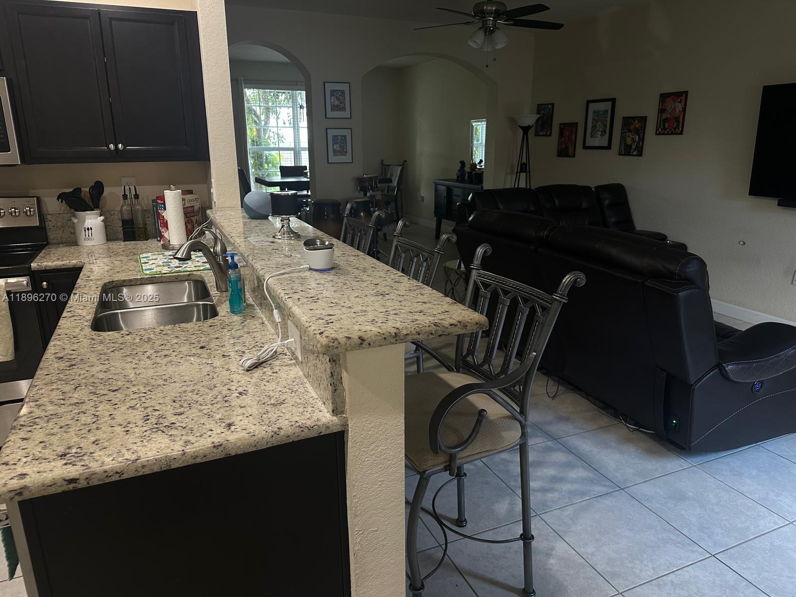 17135 Southwest 96th Street Miami, FL 33196 - Photo 10 of 34 a kitchen with granite countertop sink a stove and cabinets