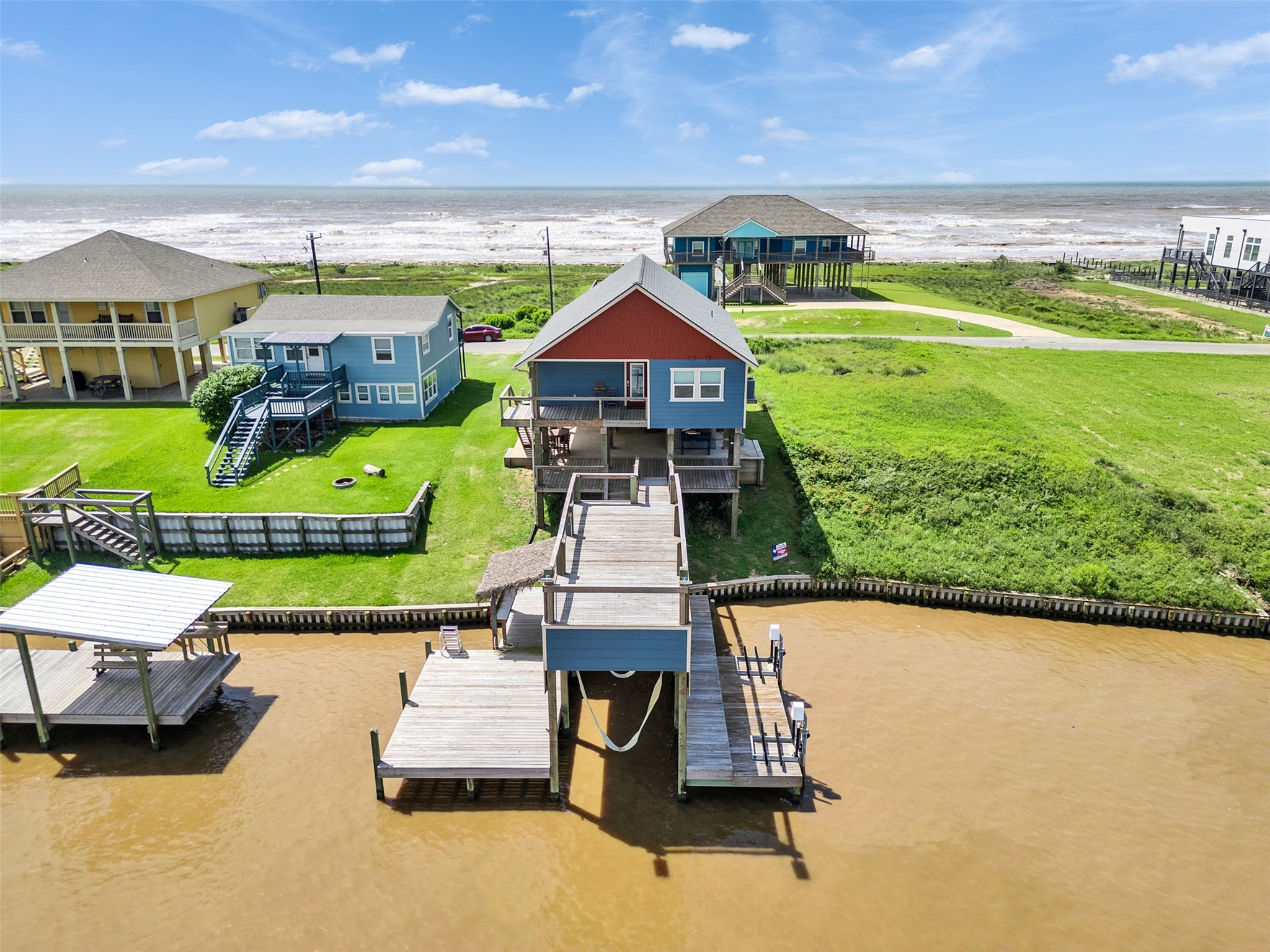 1453 County Road 230 Sargent, TX 77414 - Photo 22 of 38 This waterfront property features a charming house with a spacious walk-up deck and private dock, offering stunning ocean views. Perfect for those seeking a serene beachside lifestyle.