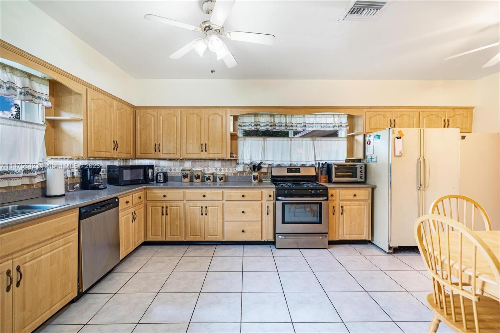 280 Eucalyptus Drive Hialeah, FL 33010 - Photo 17 of 38 a kitchen with stainless steel appliances granite countertop a refrigerator and a stove top oven