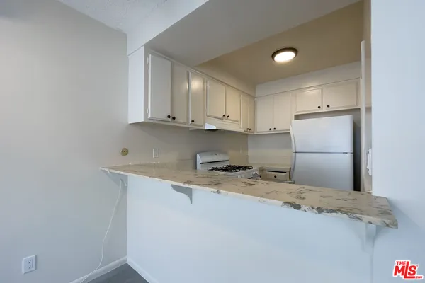 a kitchen with a sink a refrigerator and cabinets