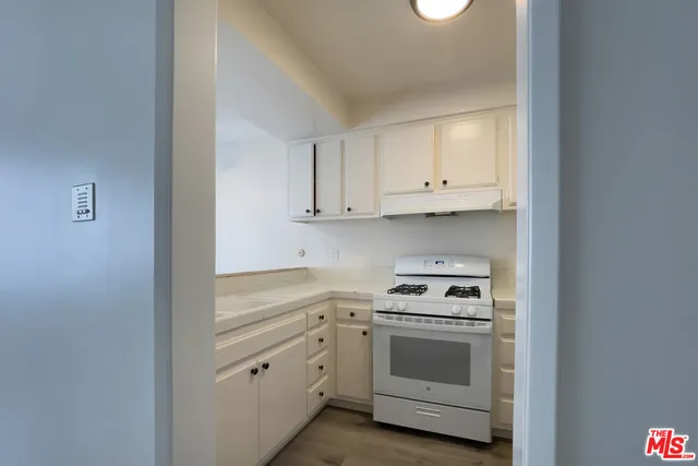 a kitchen with white cabinets and white appliances