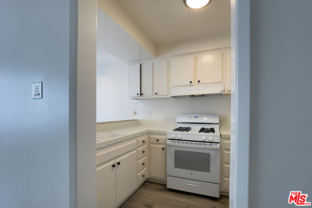 3607 Clarington Avenue, Unit 2 Los Angeles, CA 90034 - Photo 5 of 11 a kitchen with white cabinets and white appliances