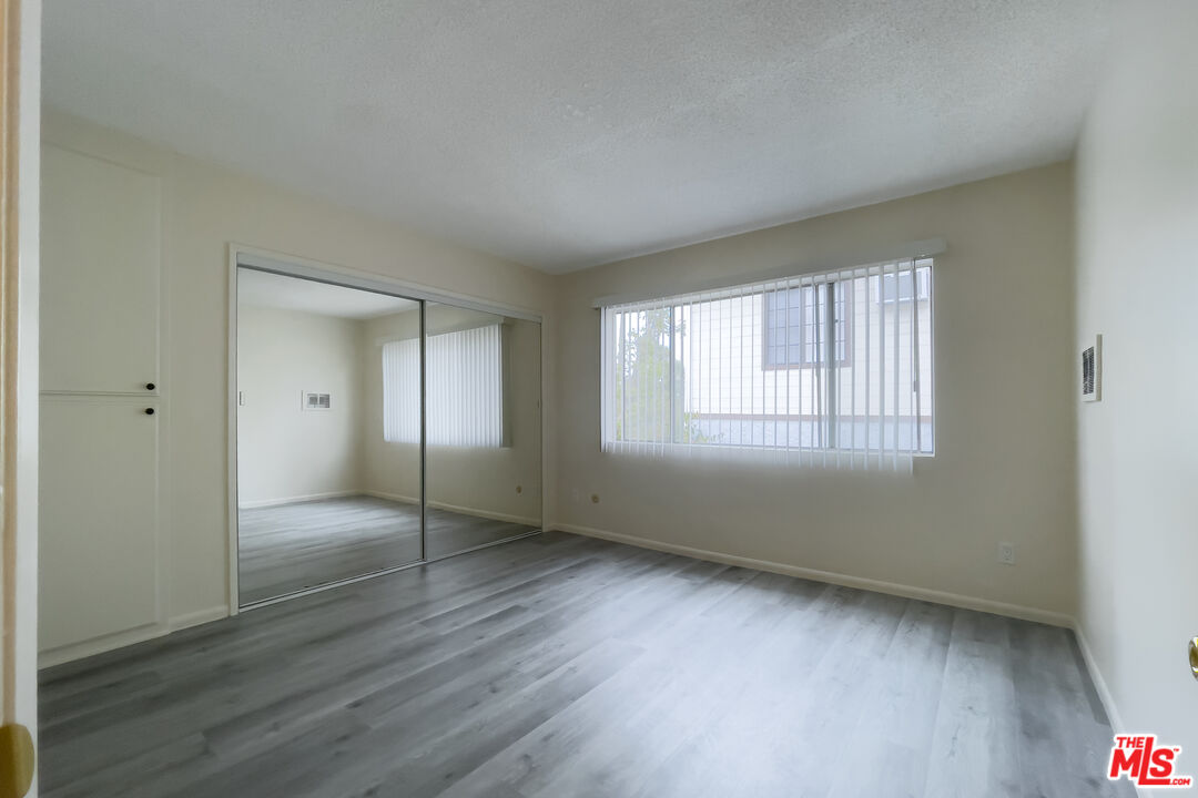 3607 Clarington Avenue, Unit 2 Los Angeles, CA 90034 - Photo 6 of 11 a view of an empty room with wooden floor and a window
