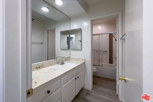 a bathroom with a double vanity sink and mirror with shower