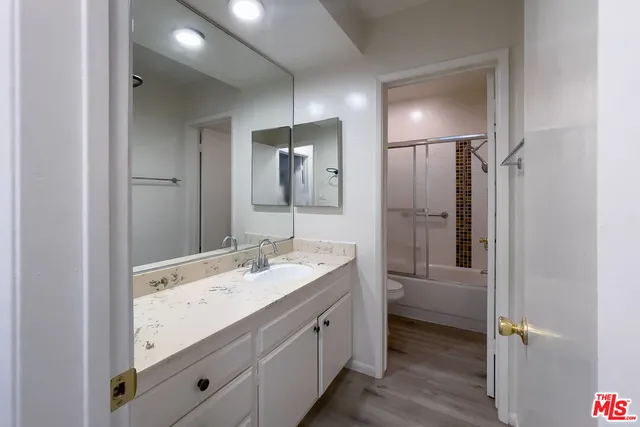 a bathroom with a double vanity sink and mirror with shower