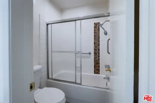 a bathroom with a shower toilet and sink