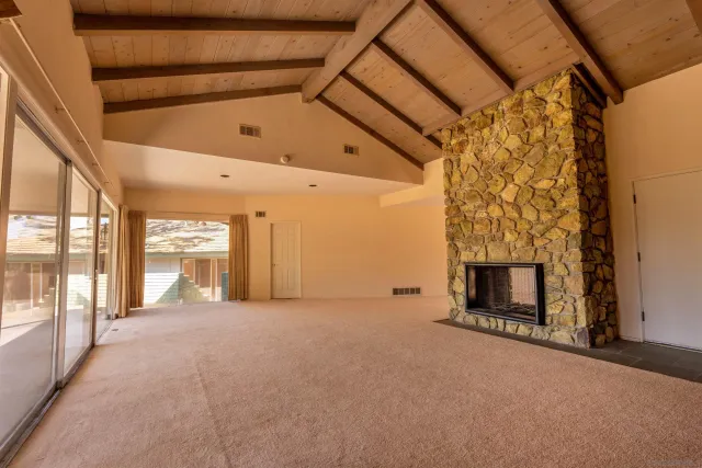 a view of an empty room with a fireplace and a window