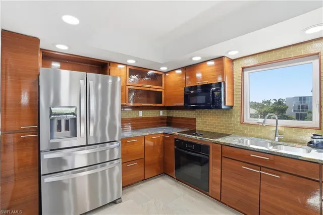 a kitchen with stainless steel appliances granite countertop a refrigerator and a sink