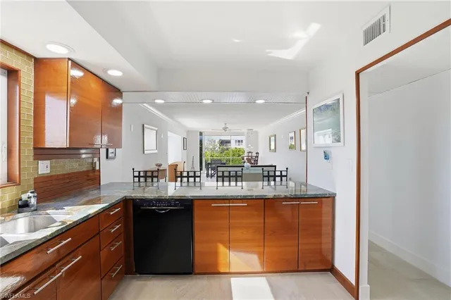 a kitchen with kitchen island granite countertop a sink and cabinets