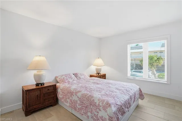 a bedroom with a bed and a lamp next to a window