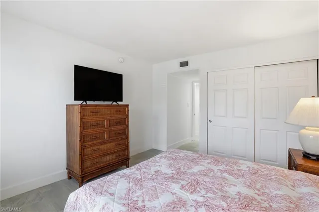 a bedroom with a bed and flat screen tv