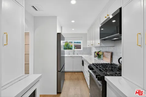 a kitchen with a sink a stove and cabinets