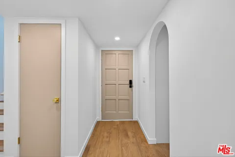 a view of a hallway with wooden floor and closet