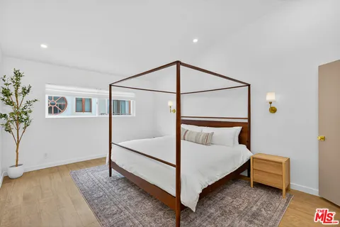 a bedroom with a bed and a potted plant