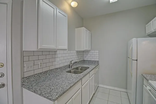 a kitchen with granite countertop a sink and a white stove