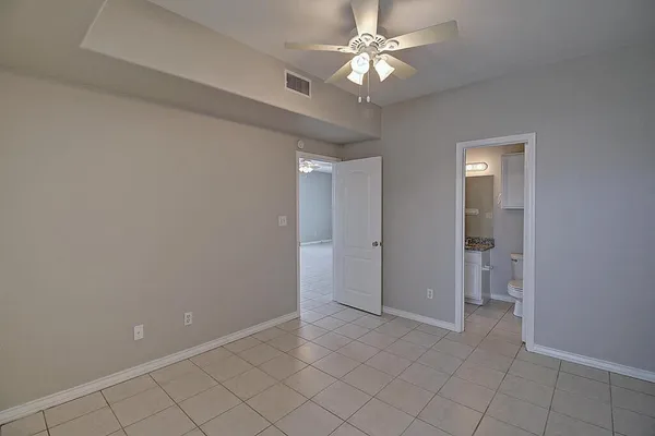 an empty room with chandelier fan