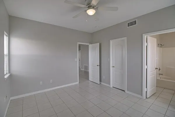 an empty room with closet and windows