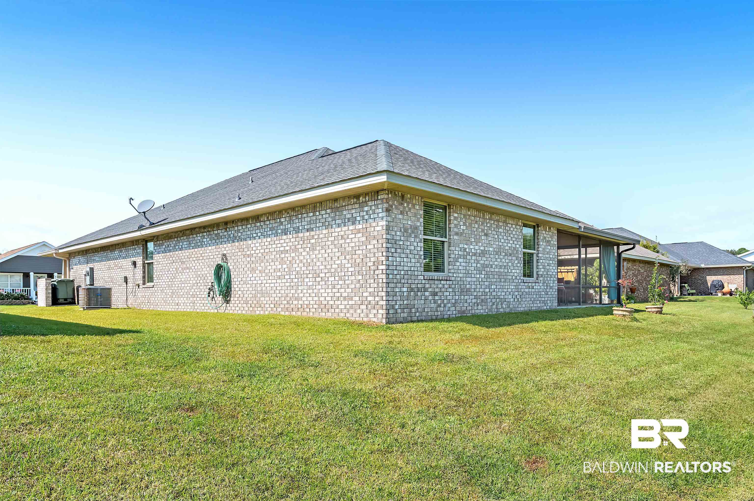 8896 Allay Lane Foley, AL 36535 - Photo 6 of 57 View of home's exterior featuring central air condition unit, a sunroom, and a lawn