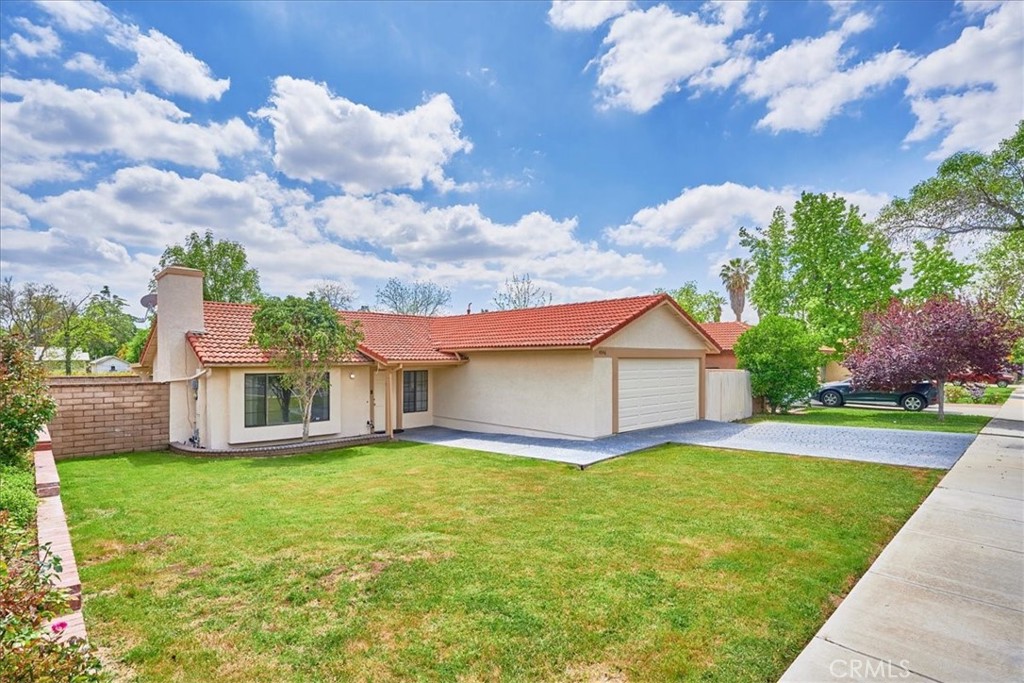 a view of a house with a big yard plants and large trees