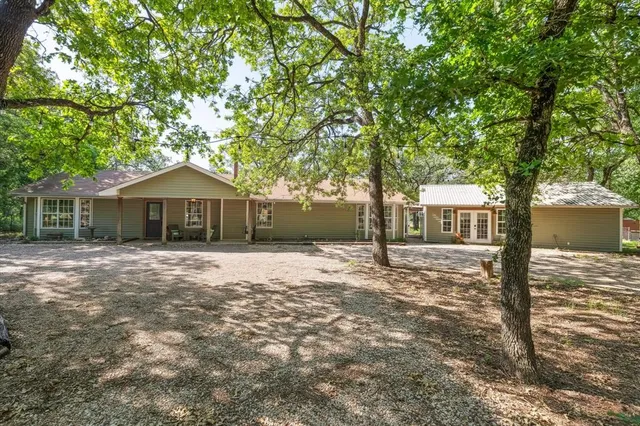 a front view of a house with a garden and tree