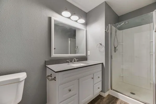 a bathroom with a granite countertop sink mirror and a toilet