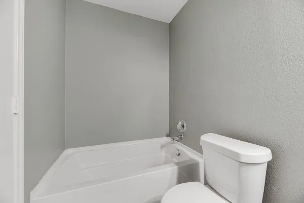 a white toilet sitting next to a bathtub