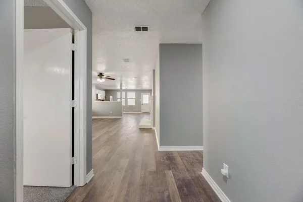 a view of a kitchen from the hallway with a room