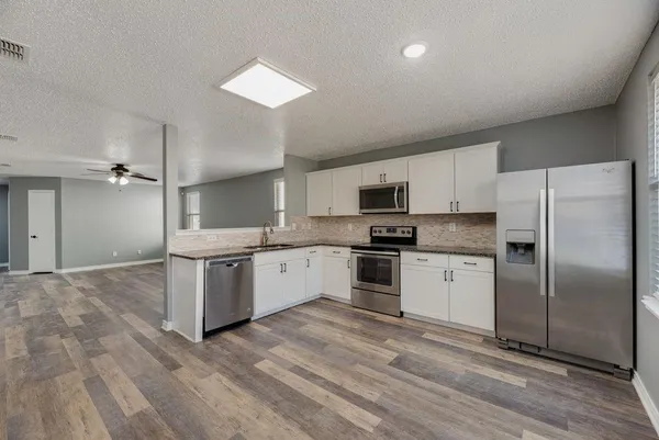 a kitchen with stainless steel appliances a refrigerator sink and microwave