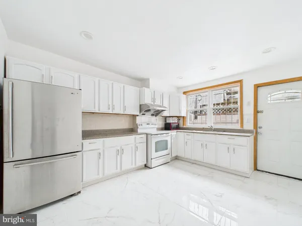 a kitchen with white cabinets and white appliances