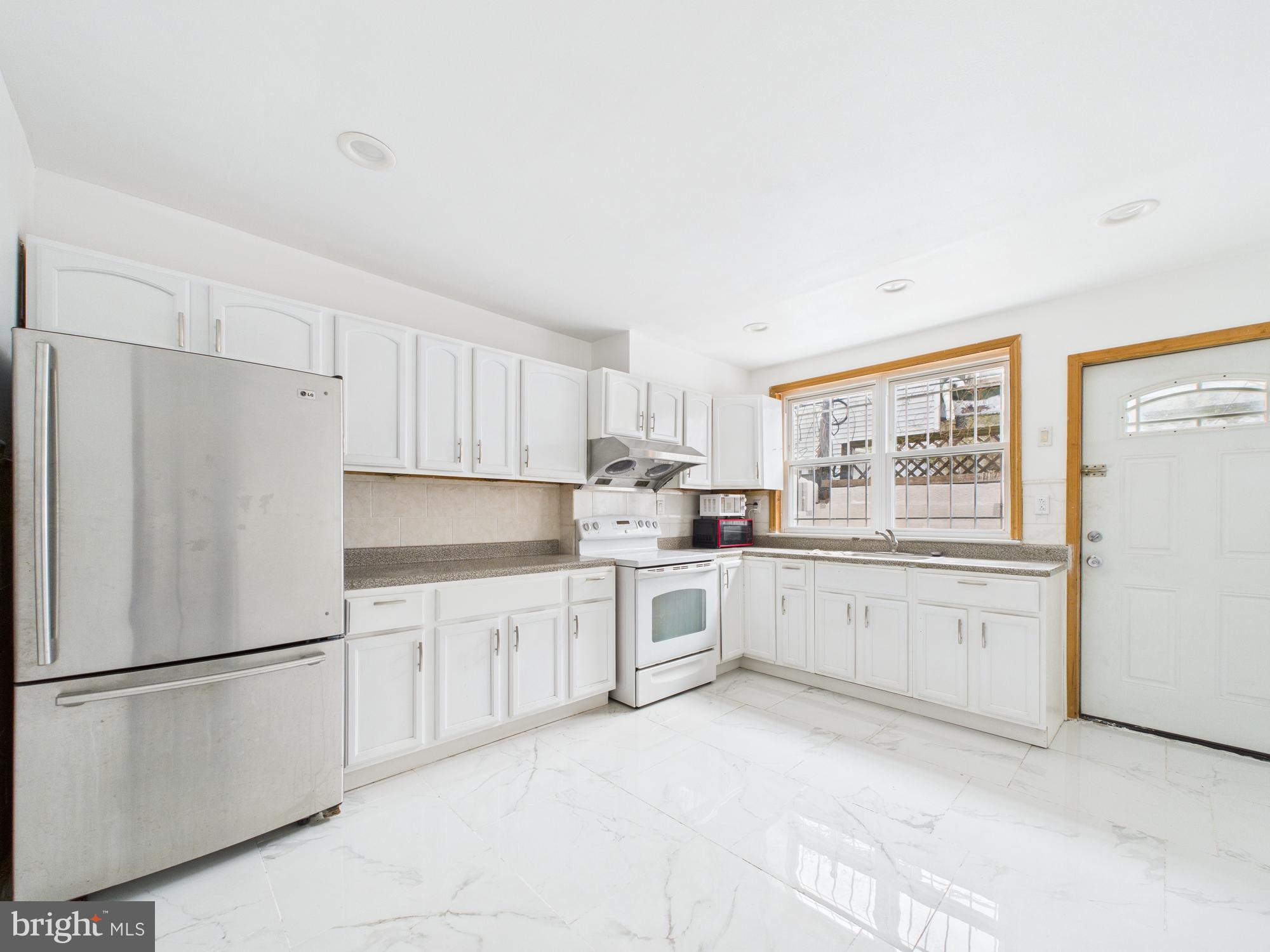 628 McClellan Street Philadelphia, PA 19148 - Photo 3 of 7 a kitchen with white cabinets and white appliances