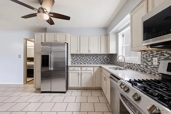 a kitchen with stainless steel appliances granite countertop a stove a refrigerator and a sink