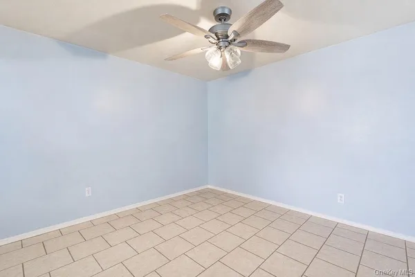an empty room with a chandelier fan