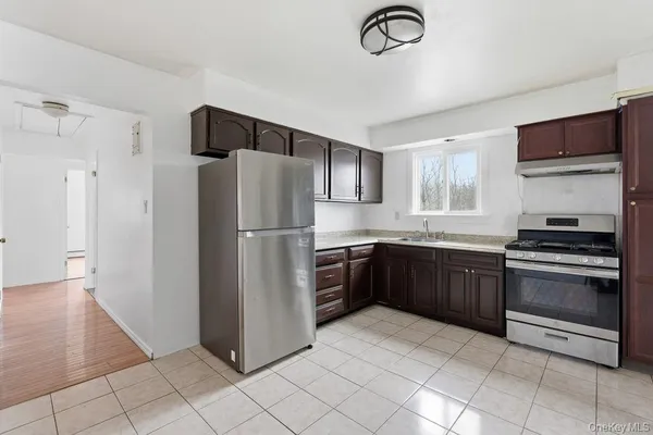 a kitchen with stainless steel appliances granite countertop a refrigerator a stove a sink and a microwave