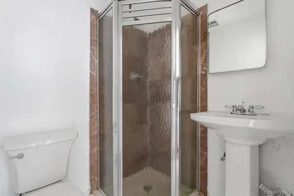 a bathroom with a sink a toilet and shower