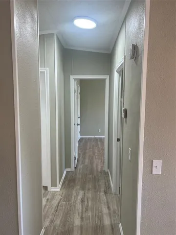an empty room with wooden floor chandelier fan and windows