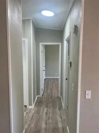 an empty room with wooden floor chandelier fan and windows
