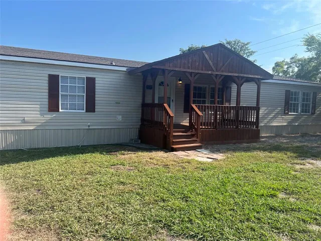 a backyard of a house with barbeque oven table and chairs
